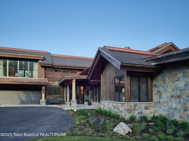 3220 N Teton Pines Dr, Wilson, WY 83014 - view of front of house featuring stone siding, asphalt driveway, and a garage