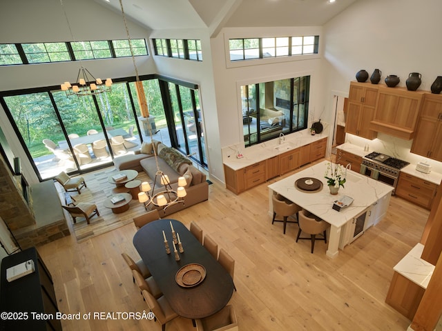 3220 N Teton Pines Dr, Wilson, WY 83014 - living room with high vaulted ceiling, a chandelier, and light wood-style floors