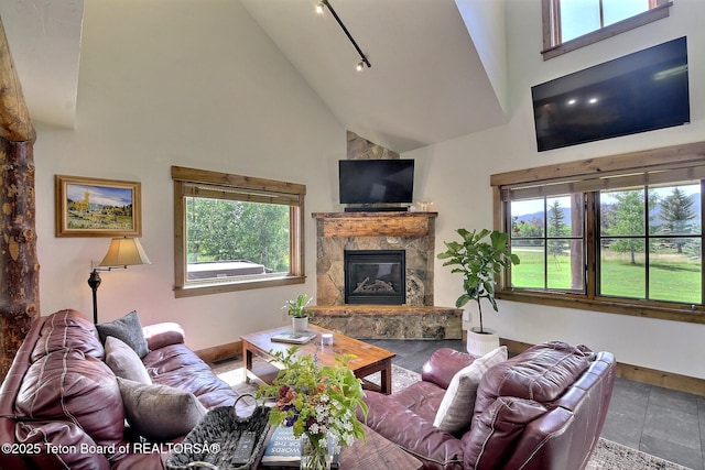 2160 Tomahawk Trl, Victor, ID 83455 - living area with high vaulted ceiling, healthy amount of natural light, a glass covered fireplace, and track lighting
