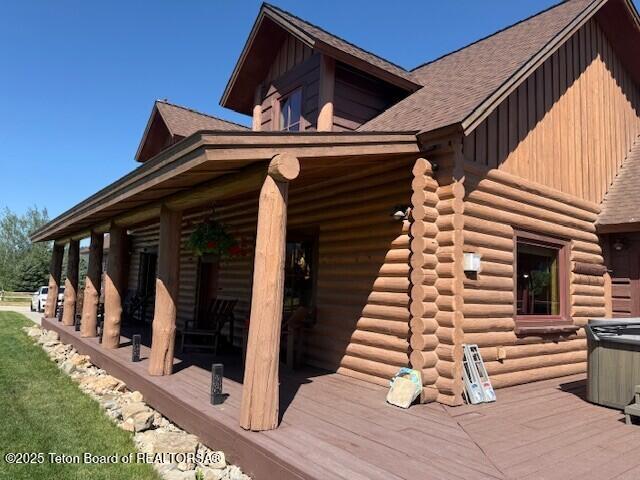 2160 Tomahawk Trl, Victor, ID 83455 - view of home's exterior with board and batten siding, log exterior, roof with shingles, and a deck