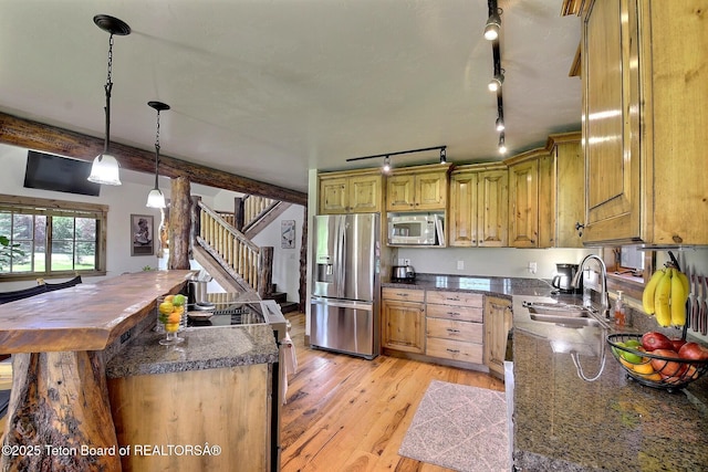 2160 Tomahawk Trl, Victor, ID 83455 - kitchen with stainless steel appliances, light wood-style flooring, a center island, rail lighting, and decorative light fixtures