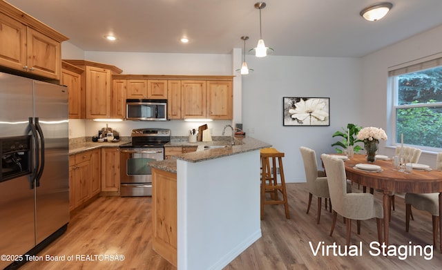 80 Eva Ln Unit 14, Victor, ID 83455 - kitchen featuring stainless steel appliances, a peninsula, light stone countertops, light wood-type flooring, and recessed lighting