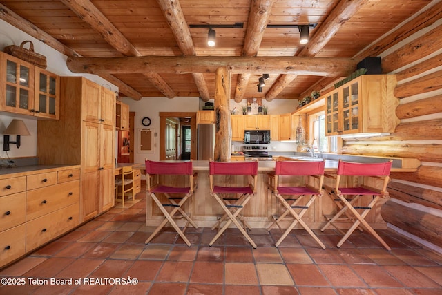 3760 N Moose-Wilson Rd, Wilson, WY 83014 - kitchen with a wooden ceiling with exposed beams, appliances with stainless steel finishes, light brown cabinets, a peninsula, and a breakfast bar