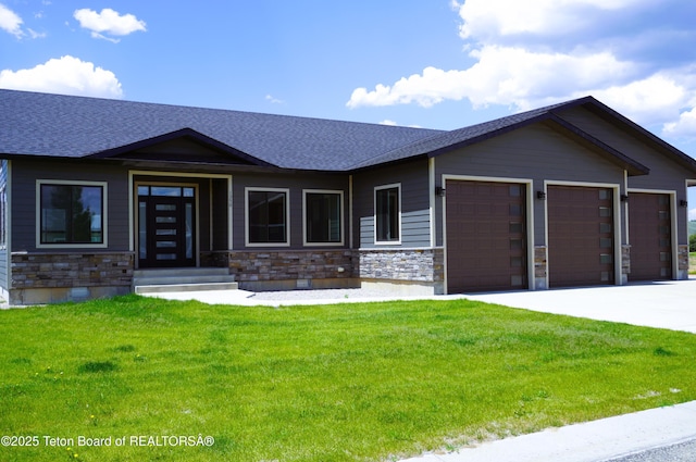 1350 Arroyo, Pinedale, WY 82941 - view of front facade with a garage, stone siding, a front yard, a shingled roof, and driveway