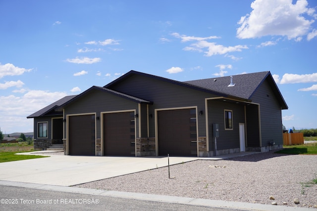 1350 Arroyo, Pinedale, WY 82941 - view of front of property with a garage, driveway, and stone siding