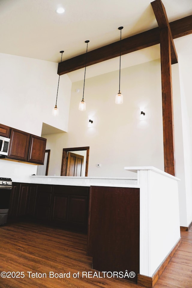 1350 Arroyo, Pinedale, WY 82941 - kitchen with gas stove, wood finished floors, dark brown cabinets, beamed ceiling, and hanging light fixtures