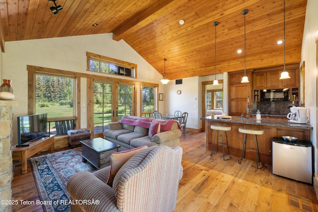 500 E Buckwheat Cir, Jackson, WY 83001 - living room with high vaulted ceiling, light wood-style flooring, french doors, and a wooden ceiling with exposed beams