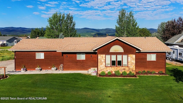 158 Holly Dr, Star Valley Ranch, WY 83127 - back of property featuring a mountain view, a lawn, stone siding, and roof with shingles