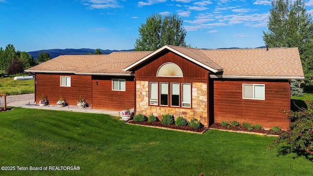 158 Holly Dr, Star Valley Ranch, WY 83127 - view of front of house with stone siding, a front lawn, roof with shingles, and a mountain view