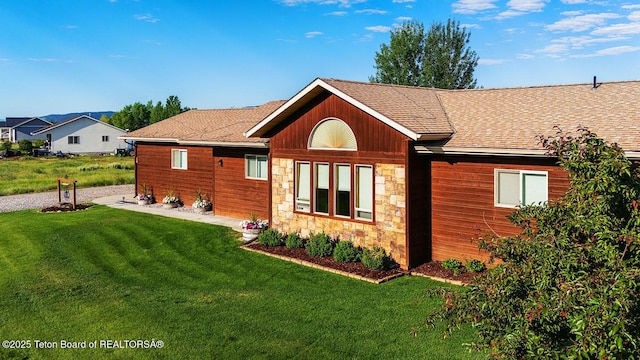 158 Holly Dr, Star Valley Ranch, WY 83127 - back of house with stone siding, a lawn, and a shingled roof