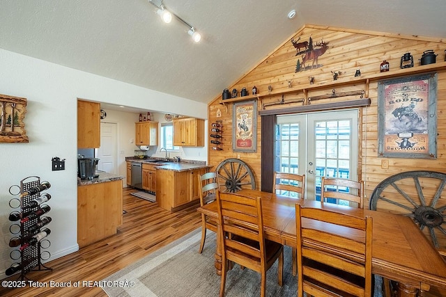 158 Holly Dr, Star Valley Ranch, WY 83127 - dining space with lofted ceiling, french doors, wood walls, light wood-type flooring, and plenty of natural light