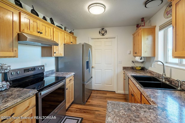 158 Holly Dr, Star Valley Ranch, WY 83127 - kitchen with stainless steel appliances, under cabinet range hood, wood finished floors, a textured ceiling, and light brown cabinetry