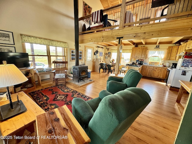 109 E Fontenelle Dr, Daniel, WY 83115 - living area with a wood stove, light wood-style flooring, a towering ceiling, and beamed ceiling