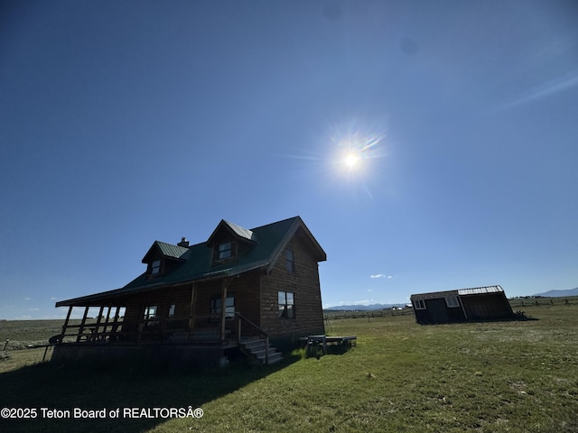 109 E Fontenelle Dr, Daniel, WY 83115 - view of front of house with a porch, a front lawn, a chimney, an outbuilding, and a mountain view