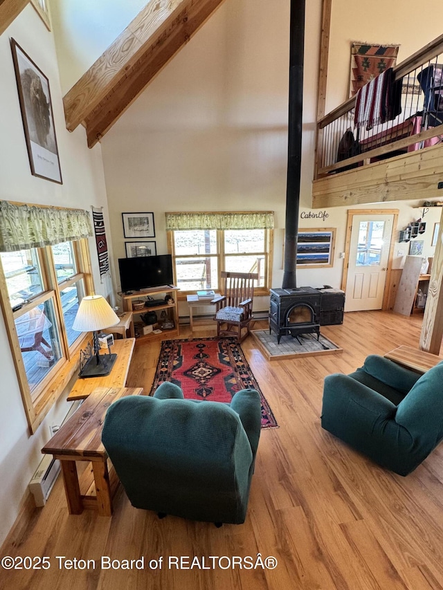 109 E Fontenelle Dr, Daniel, WY 83115 - living room featuring high vaulted ceiling, a wood stove, wood finished floors, beamed ceiling, and a baseboard radiator
