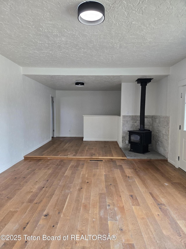 6270 S 3rd St, Tetonia, ID 83452 - basement featuring hardwood / wood-style floors, a textured ceiling, and a wood stove