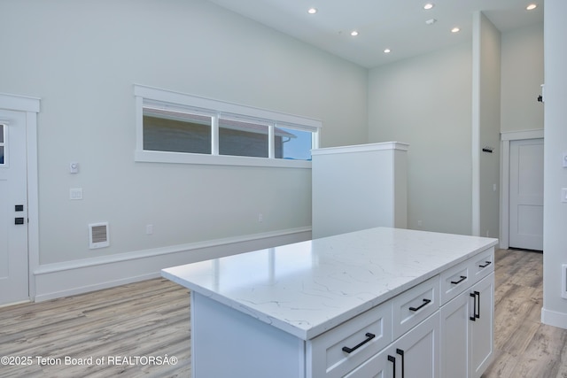 151 Stonefly Ln, Swan Valley, ID 83449 - kitchen with white cabinets, recessed lighting, light wood-type flooring, light stone counters, and a center island