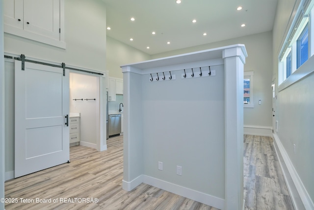 151 Stonefly Ln, Swan Valley, ID 83449 - corridor featuring a barn door, recessed lighting, light wood-style floors, and a high ceiling