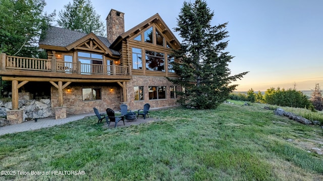 8157 Ripplinger Rd, Driggs, ID 83422 - rear view of house featuring a chimney, a yard, a wooden deck, log siding, and stone siding