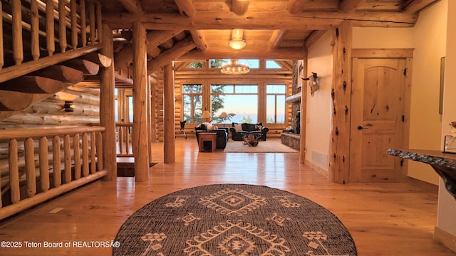 8157 Ripplinger Rd, Driggs, ID 83422 - entrance foyer with hardwood / wood-style floors, a chandelier, a wood ceiling with exposed beams, rustic walls, and a fireplace