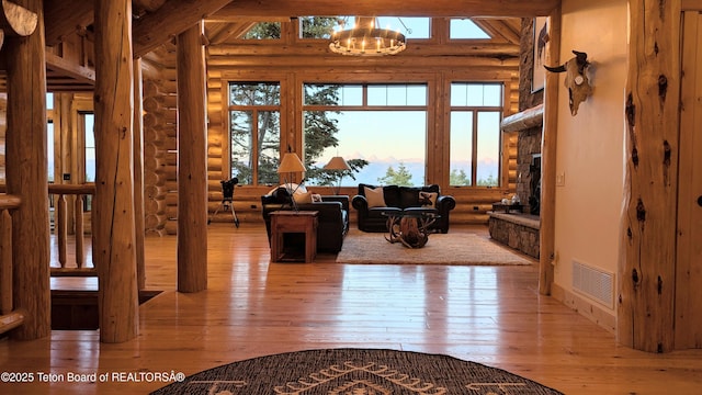 8157 Ripplinger Rd, Driggs, ID 83422 - living room with log walls, hardwood / wood-style floors, plenty of natural light, and a stone fireplace