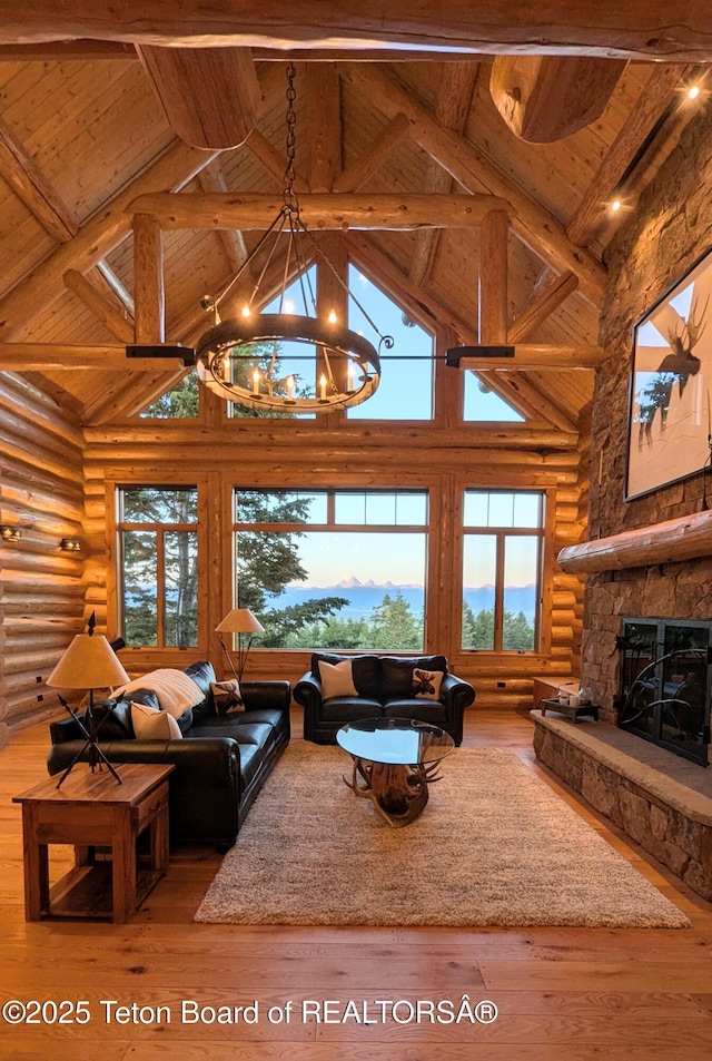 8157 Ripplinger Rd, Driggs, ID 83422 - living room with high vaulted ceiling, log walls, healthy amount of natural light, a wood ceiling with exposed beams, and wood-type flooring