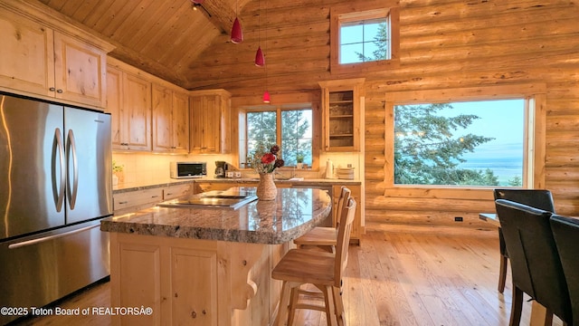 8157 Ripplinger Rd, Driggs, ID 83422 - kitchen featuring appliances with stainless steel finishes, light wood finished floors, wood ceiling, healthy amount of natural light, and a breakfast bar