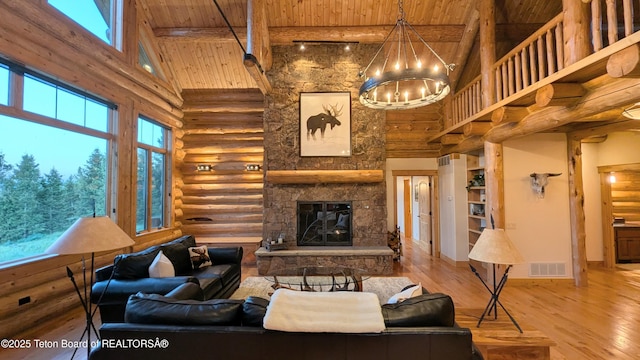 8157 Ripplinger Rd, Driggs, ID 83422 - living area with a wood ceiling with exposed beams, high vaulted ceiling, rustic walls, wood finished floors, and a stone fireplace