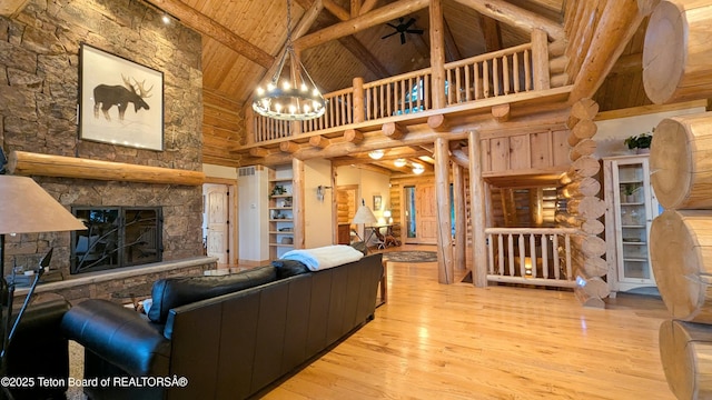8157 Ripplinger Rd, Driggs, ID 83422 - living area featuring high vaulted ceiling, a wooden ceiling with exposed beams, hardwood / wood-style floors, a stone fireplace, and a ceiling fan