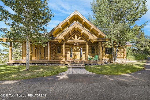8157 Ripplinger Rd, Driggs, ID 83422 - cabin featuring log exterior, a porch, and a front lawn
