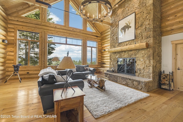 8157 Ripplinger Rd, Driggs, ID 83422 - living room with rustic walls, high vaulted ceiling, light wood-type flooring, a fireplace, and healthy amount of natural light