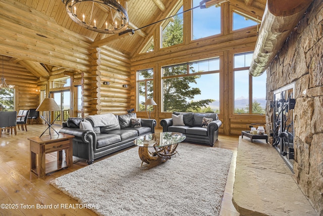 8157 Ripplinger Rd, Driggs, ID 83422 - living room featuring high vaulted ceiling, log walls, a chandelier, a wooden ceiling with exposed beams, and light wood-type flooring