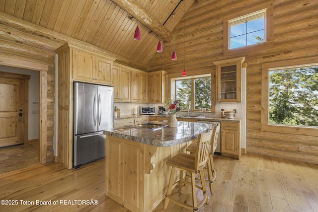 8157 Ripplinger Rd, Driggs, ID 83422 - kitchen with appliances with stainless steel finishes, a wooden ceiling with exposed beams, a center island, light brown cabinetry, and glass insert cabinets