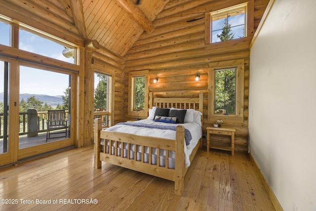 8157 Ripplinger Rd, Driggs, ID 83422 - bedroom with access to outside, a mountain view, wood-type flooring, log walls, and a wood ceiling with exposed beams