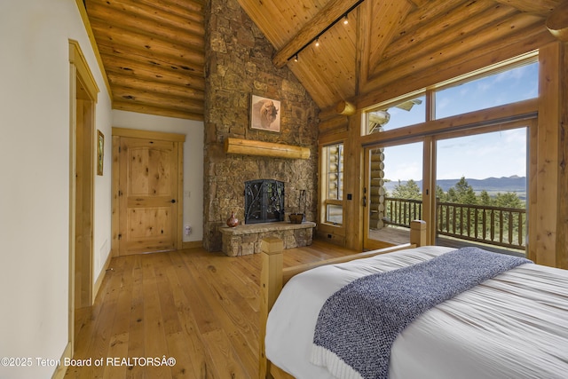 8157 Ripplinger Rd, Driggs, ID 83422 - bedroom featuring a wooden ceiling with exposed beams, high vaulted ceiling, access to exterior, a mountain view, and a stone fireplace
