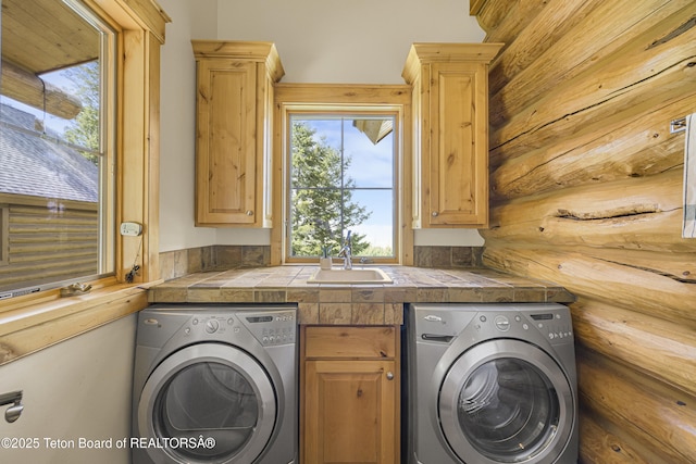 8157 Ripplinger Rd, Driggs, ID 83422 - laundry area featuring cabinet space, log walls, and washer and dryer