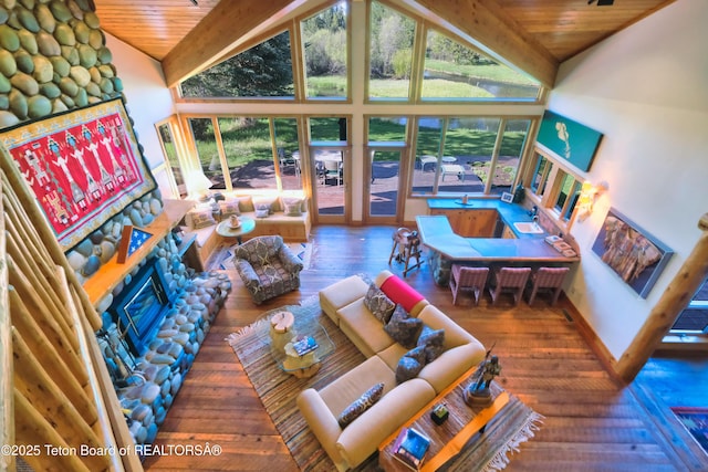 590 S Sandhill Crane Rd, Wilson, WY 83014 - living area featuring wood-type flooring, a wooden ceiling with exposed beams, high vaulted ceiling, and a stone fireplace