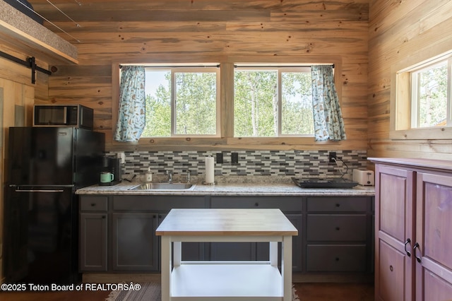 66 Elkhorn Dr, Thayne, WY 83127 - kitchen with freestanding refrigerator, stainless steel microwave, and backsplash