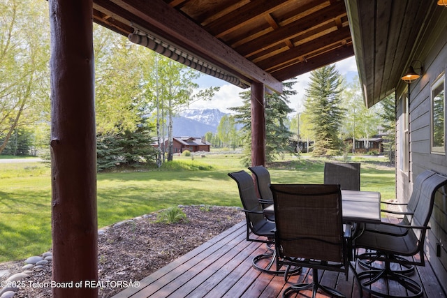 6790 N Timothy Rd, Jackson, WY 83001 - deck featuring a mountain view, a lawn, and outdoor dining space