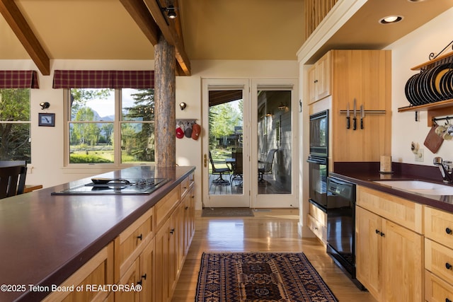 6790 N Timothy Rd, Jackson, WY 83001 - kitchen with black appliances, dark countertops, light brown cabinetry, beamed ceiling, and recessed lighting