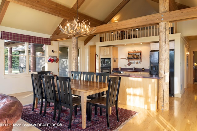 6790 N Timothy Rd, Jackson, WY 83001 - dining area with a chandelier, light wood-type flooring, beamed ceiling, ornate columns, and high vaulted ceiling