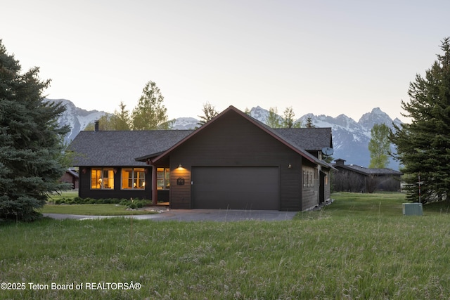 6790 N Timothy Rd, Jackson, WY 83001 - view of front facade featuring a mountain view, an attached garage, and a front lawn