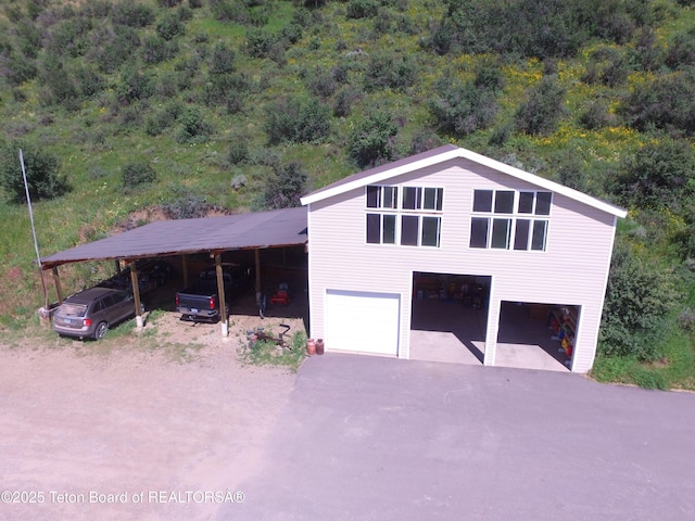 870 Sky View Ln, Afton, WY 83110 - view of front of property with asphalt driveway, a wooded view, and an attached garage