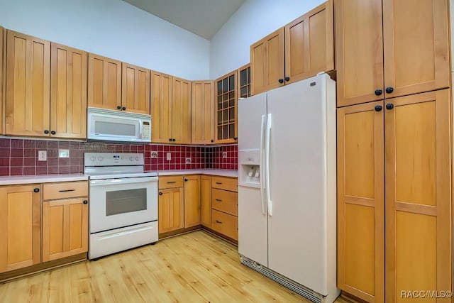 2195 W Huntington Dr, Beverly Hills, FL 34465 - kitchen with white appliances, light countertops, backsplash, light wood-style flooring, and glass insert cabinets