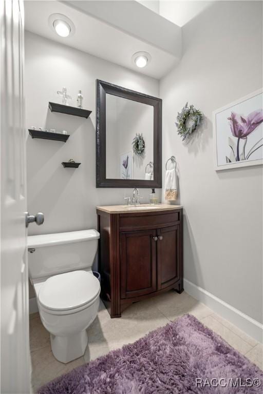 bathroom featuring tile patterned flooring, vanity, and toilet