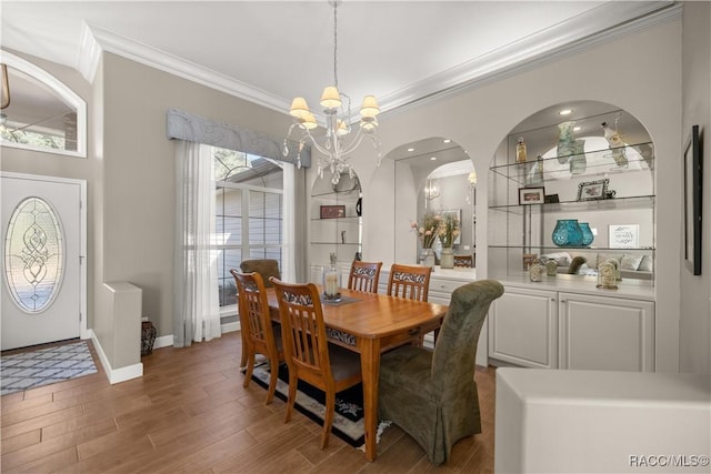 dining space featuring ornamental molding, dark hardwood / wood-style floors, and a notable chandelier