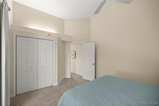 bedroom featuring light colored carpet, a closet, and ceiling fan