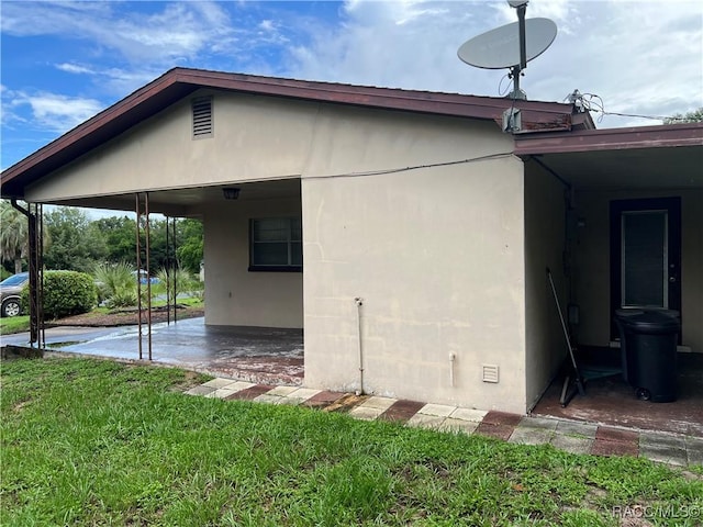 13 N Wadsworth Ave, Beverly Hills, FL 34465 - view of side of home featuring a lawn, stucco siding, and a patio