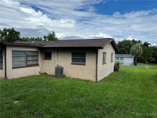 13 N Wadsworth Ave, Beverly Hills, FL 34465 - view of side of home featuring stucco siding, a lawn, and a garage