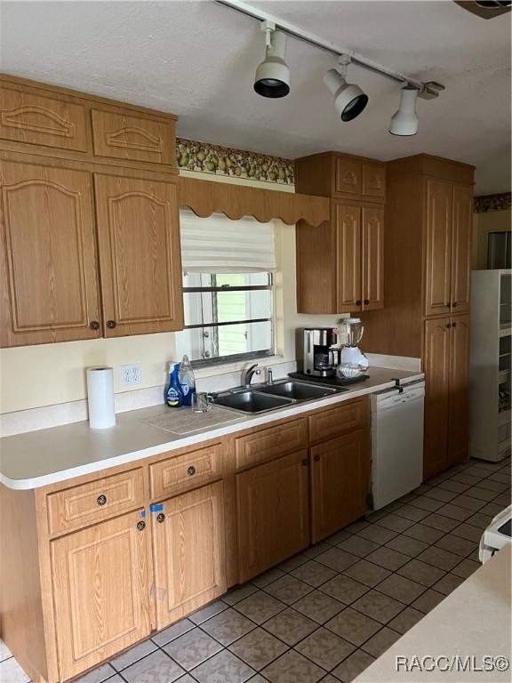 13 N Wadsworth Ave, Beverly Hills, FL 34465 - kitchen featuring white dishwasher, light tile patterned flooring, fridge, and light countertops